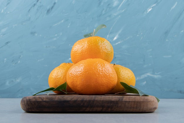 Delicious tangerine fruits on wooden board. 