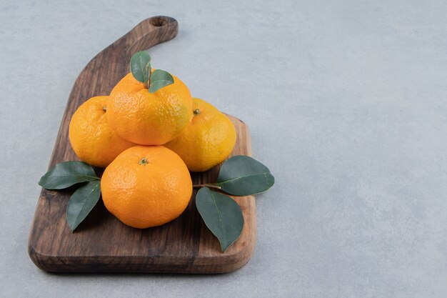 Delicious tangerine fruits on wooden board