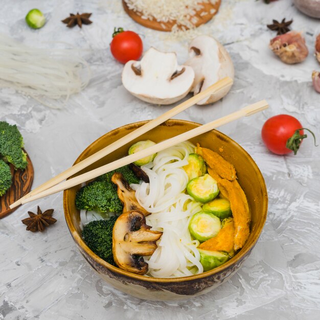 Delicious tasty food in bowl with raw ingredients and spices