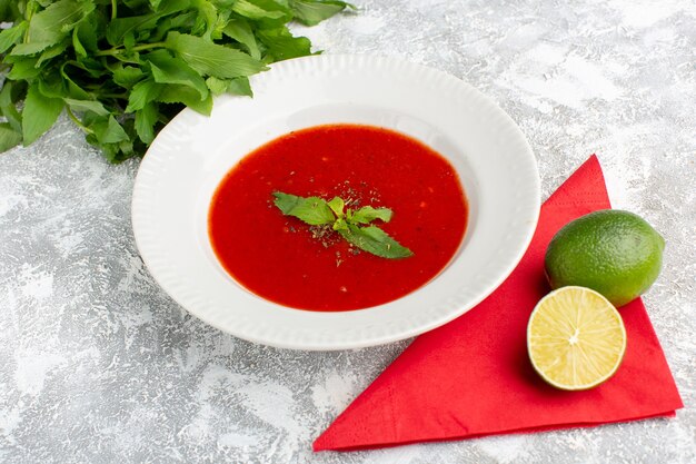 delicious tomato soup with lemon and greens on grey, soup meal dinner vegetable