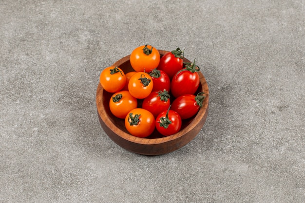 Вкусные помидоры в миске, на мраморе.