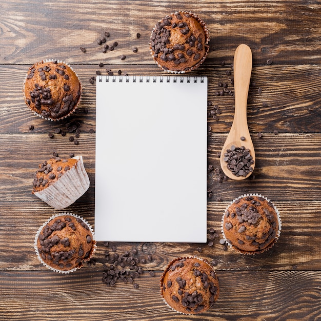 Foto gratuita muffin deliziosi di vista superiore con il blocco note