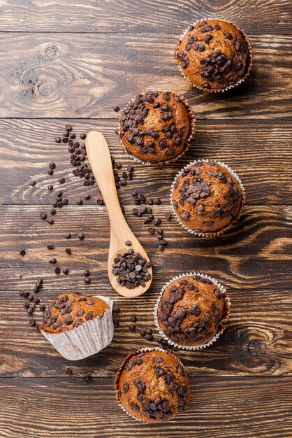 Delicious top view muffins on wooden background