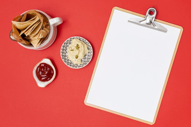 Delicious tortilla with dips next to clipboard