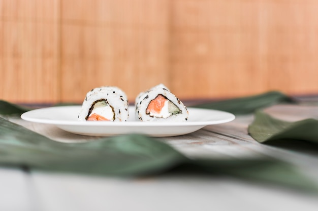 Delicious traditional sushi on plate over table