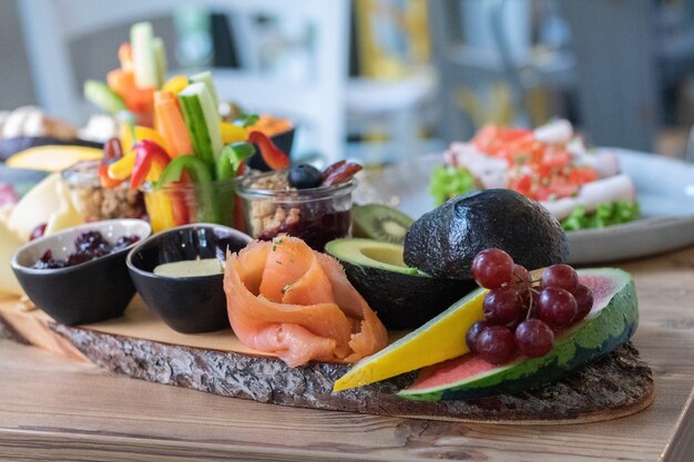 Вкусные и разнообразные нарезанные фрукты и овощи на деревянной доске