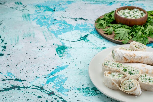 delicious vegetable rolls whole and sliced with greens and salad on blue, food meal roll vegetable snack