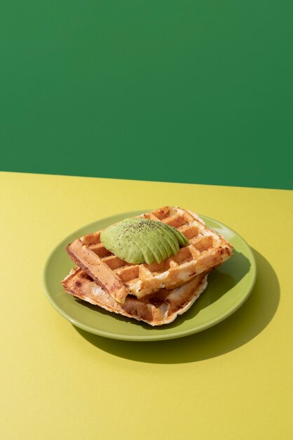 Delicious waffles with avocado high angle