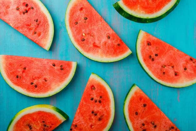 Delicious watermelon slices on blue background, top view.