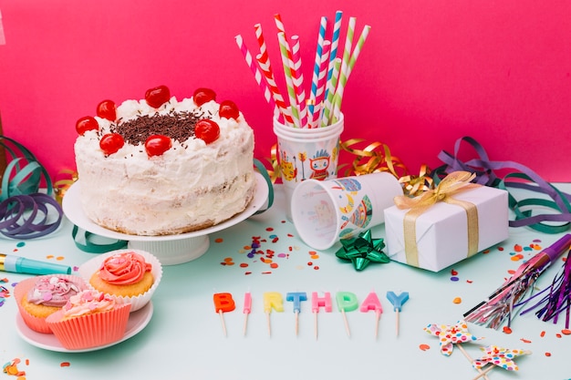 Delicious white cake with party accessories on dual background