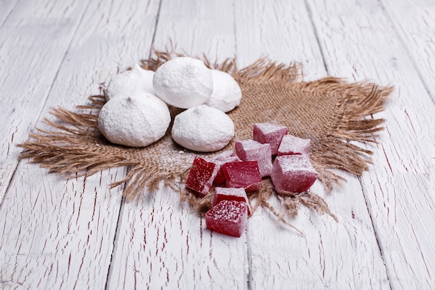 Delicious white and red cookies for tea served on white wooden table