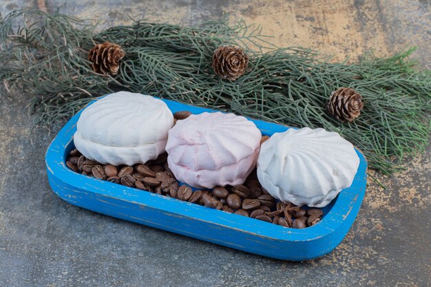Бесплатное фото Вкусный зефир с кофейными зернами в голубой тарелке. фото высокого качества