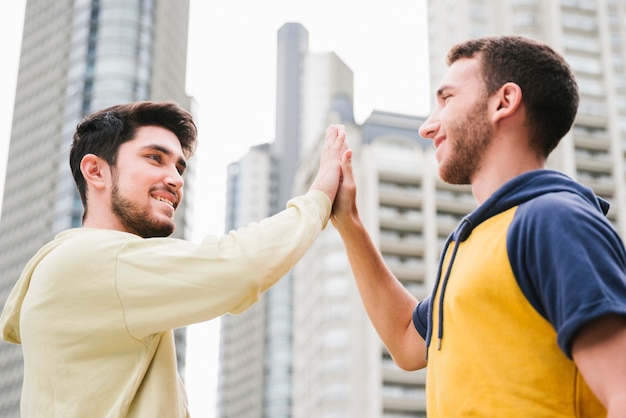 Delighted gay couple giving high five