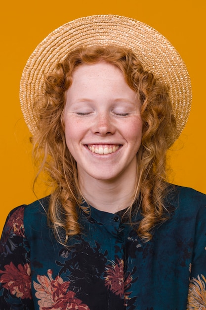 Delighted redhead female in hat in studio
