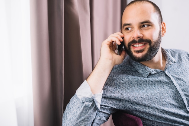 Delightful man talking near window