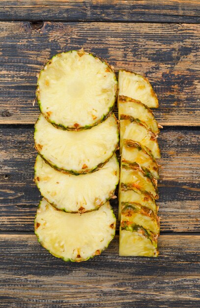 Delightful pineapple slices flat lay on old wood grunge