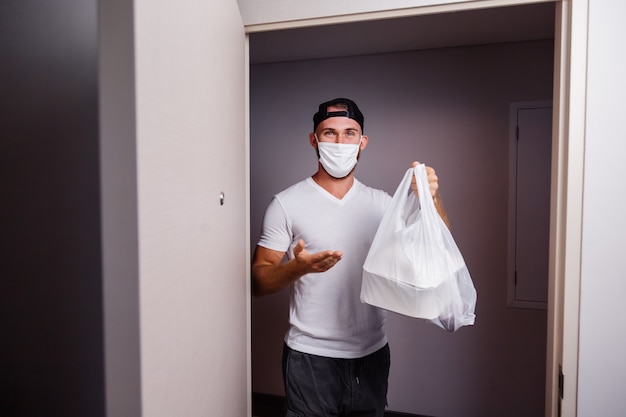 Foto gratuita consegnare l'uomo con il sacchetto di plastica con il cibo