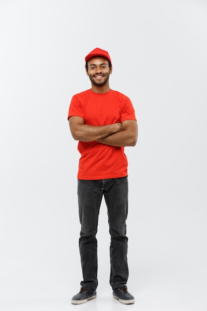 Delivery Concept - Handsome African American delivery man crossed arms over isolated on Grey studio Background. Copy Space.