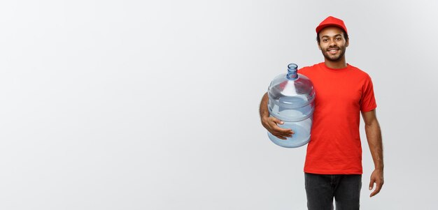 Delivery Concept Handsome African American delivery man holding water tank Isolated on Grey studio Background Copy Space