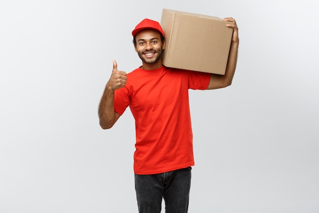 Delivery Concept - Handsome African American delivery man. Isolated on Grey studio Background. Copy Space.