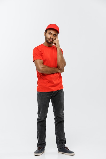 Delivery Concept - Handsome African American delivery man. Isolated on Grey studio Background. Copy Space.