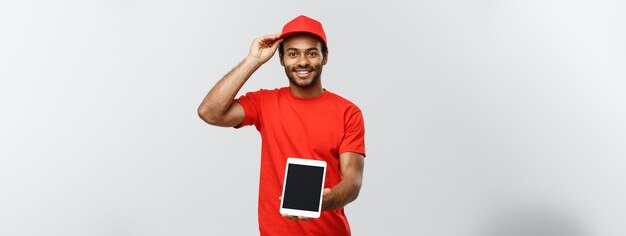 Delivery concept portrait of handsome african american delivery man or courier showing tablet on yo