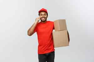 Free photo delivery concept - portrait of handsome african american delivery man or courier showing tablet on you to check the order. isolated on grey studio background. copy space.