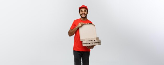 Delivery Concept Portrait of Handsome African American Pizza delivery man Isolated on Grey studio Background Copy Space