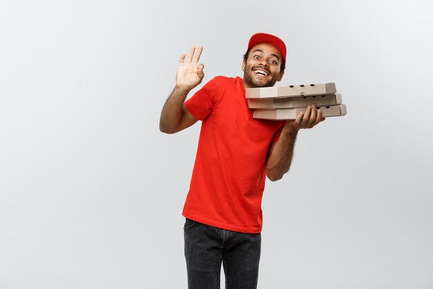 Delivery Concept - Portrait of Handsome African American Pizza delivery man. Isolated on Grey studio Background. Copy Space.