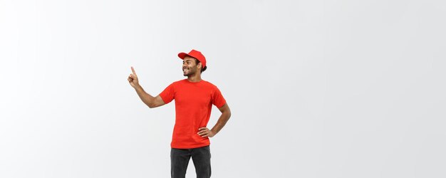Delivery Concept Portrait of Happy African American delivery man pointing hand to present something Isolated on Grey studio Background Copy Space