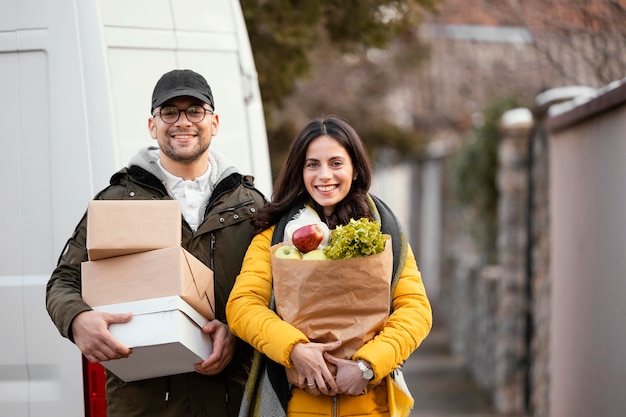 Foto gratuita addetto alle consegne con pacchetto di cibo