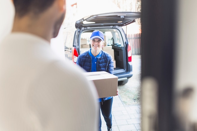 Delivery girl carrying box to customer