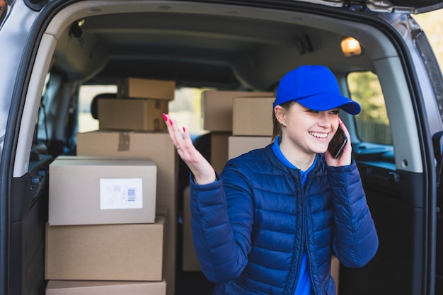 Delivery girl having phone call in car