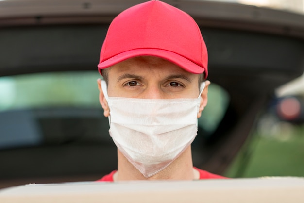 Free photo delivery guy wearing mask close-up