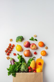 Доставка здоровой пищи фон. здоровая веганская вегетарианская еда в бумажном пакете овощей и фруктов на белом, копией пространства, баннера. шоппинг продуктовый супермаркет и концепция чистой веганской еды.