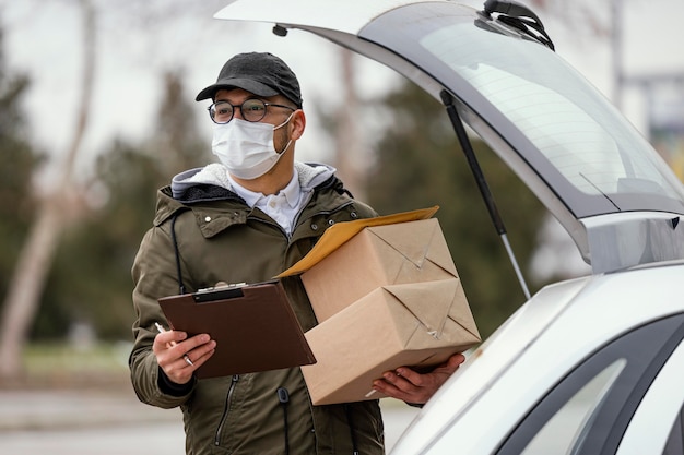 Foto gratuita consegna maschio con maschera e pacchi