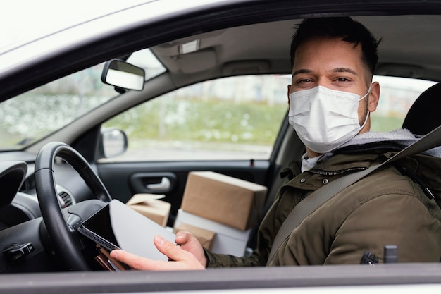 Foto gratuita consegna maschio con maschera e pacchi