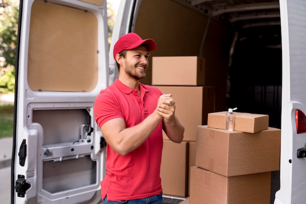 Delivery male with mask using hand sanitizer