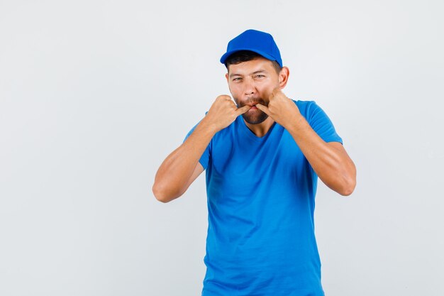 Delivery man in blue t-shirt, cap hailing or whistling