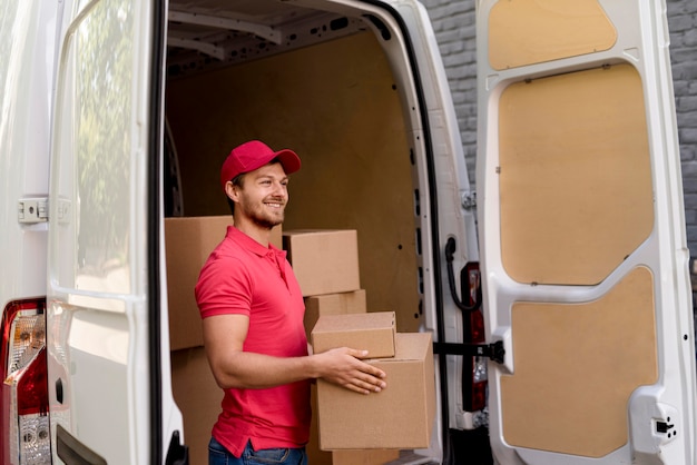 Delivery man at car carrying packages