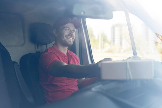 Delivery man in car with package