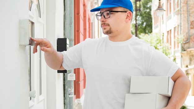 Delivery man clicking on bell medium shot