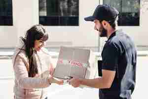 Foto gratuita uomo di consegna che consegna il pacco al cliente femminile