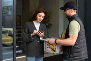 Free photo delivery man giving groceries order to customer