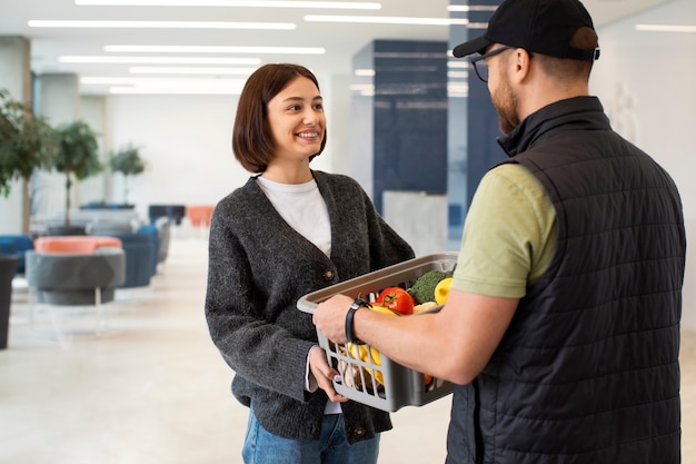 Free photo delivery man giving groceries order to customer