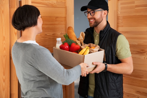 Free photo delivery man giving groceries order to customer