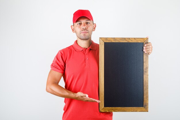 Delivery man holding blackboard in red uniform front view.