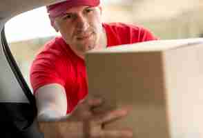 Free photo delivery man holding box