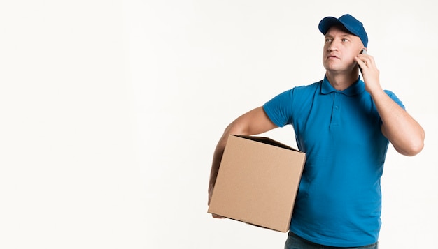 Delivery man holding cardboard box with copy space