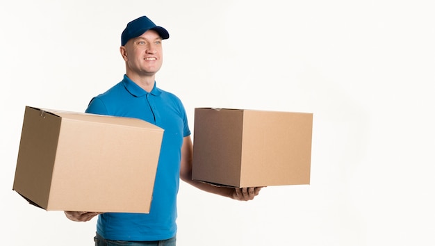 Free photo delivery man holding cardboard boxes in each hand